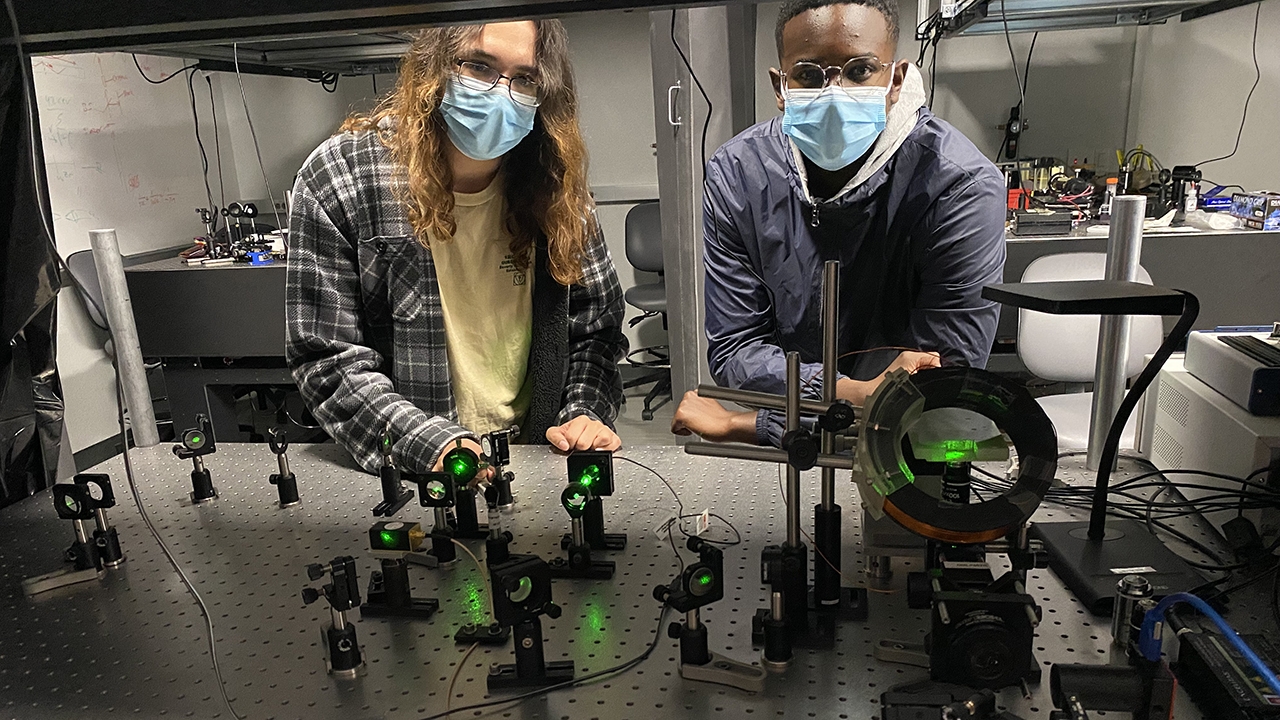 QU-REACH Program research partners Andrew Gilbert and Roberts Ituah worked on quantum sensing by analyzing the fluorescent and magnetic qualities of Nitrogen-Vacancy centers in diamond.